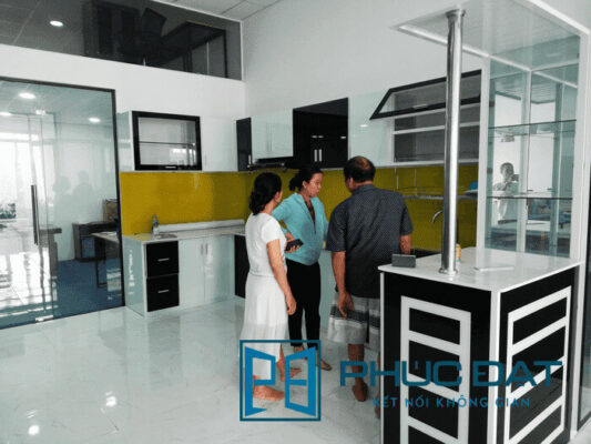 Khách hàng tham quan tủ bếp sử dụng sơn kính cao cấp của Phúc Đạt.